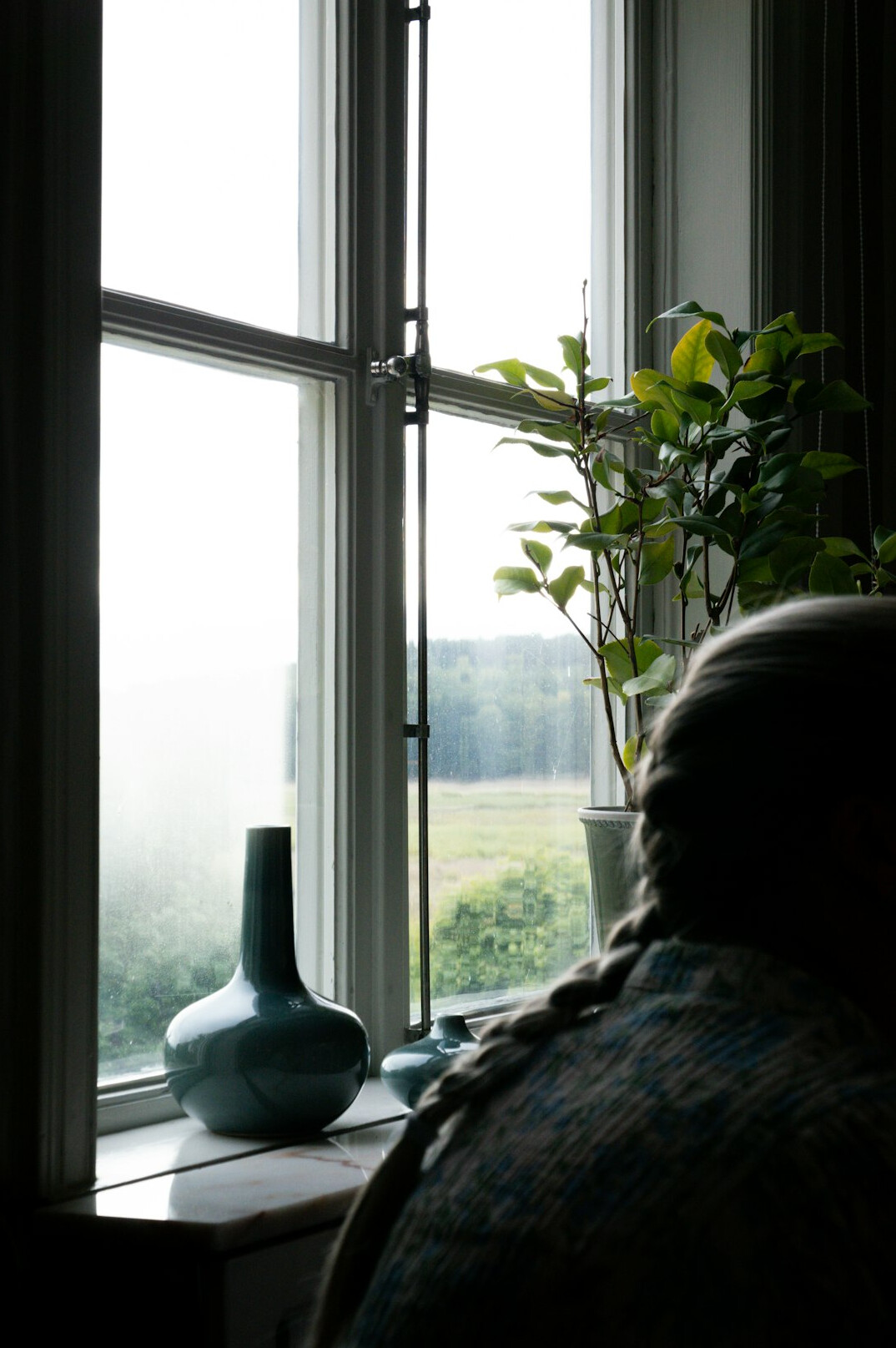 elderly person looking out window