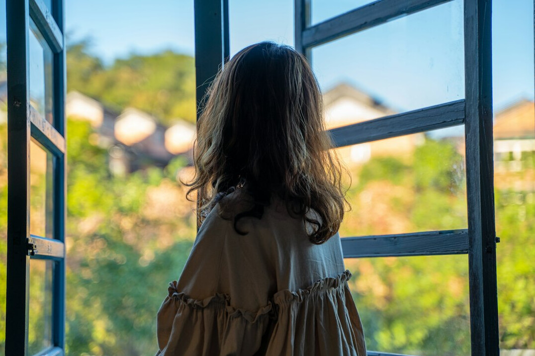 Person seen from behind looking out of a large window